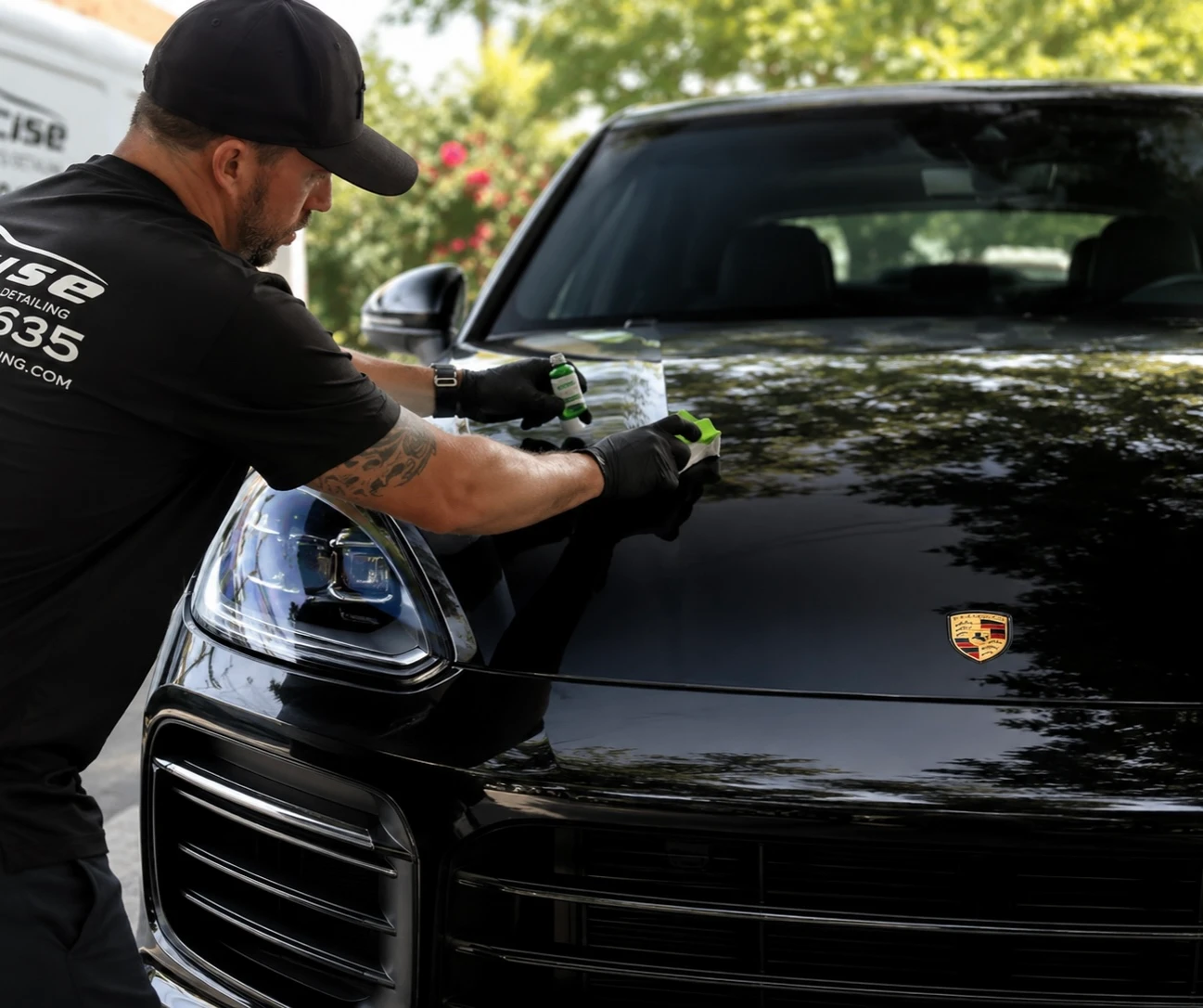 Justin working on the hood of a black Porsche