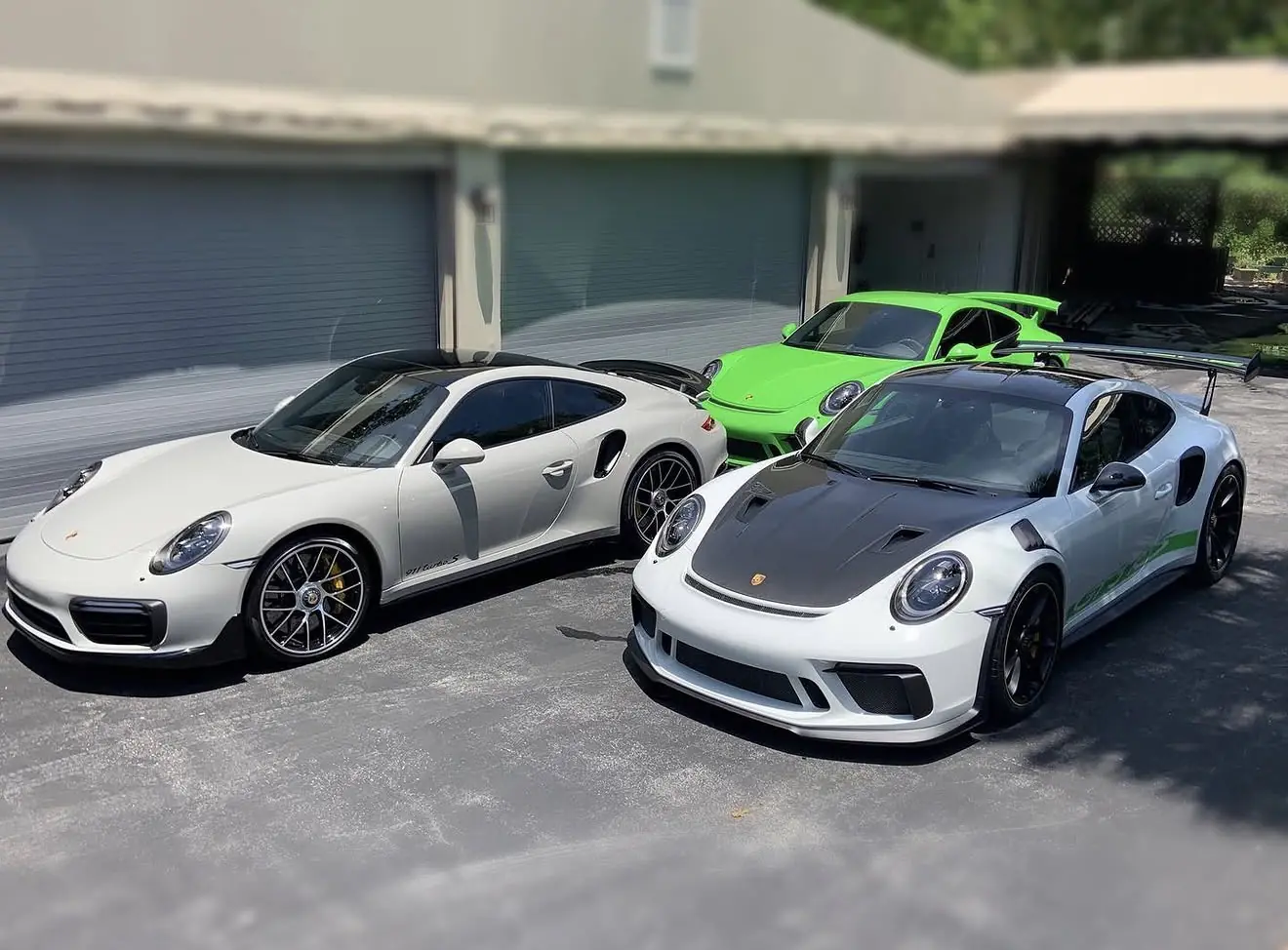 Three Porsche sports cars parked together on a driveway